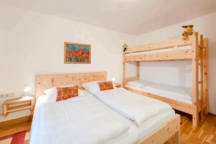 Doppelbett und Etagenbett ausunbehandeltem Zirbelkiefernholz für erholsamen Schlaf